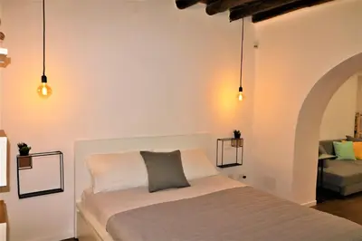 a bedroom with a bed and two pendant lights at Palermo Home White Home in Palermo