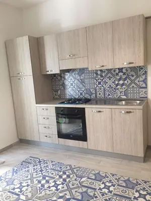 a kitchen with a stove and cabinets and a rug at Al Civico 8 - Palermo in Palermo