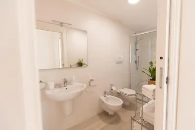 a bathroom with a sink and a toilet and a mirror at Villa Cristina - Relax - Piscina e Vista Mare in Castellammare del Golfo