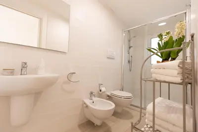 a white bathroom with a sink and a toilet at Villa Cristina - Relax - Piscina e Vista Mare in Castellammare del Golfo