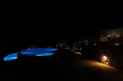 a row of blue boats lit up at night at Villa Cristina - Relax - Piscina e Vista Mare in Castellammare del Golfo