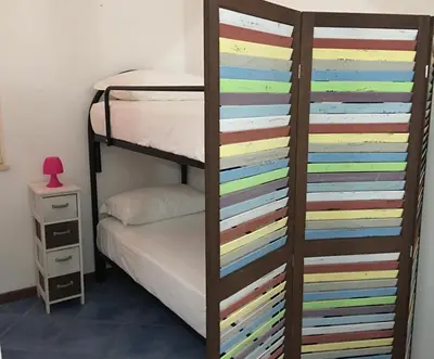 a bedroom with a bunk bed with a colorful wall at Villa dei Limoni sul Mare in Castellammare del Golfo