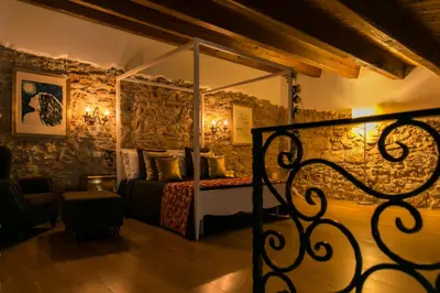 a bedroom with a bed in a room with stone walls at Borgo degli Angeli Wellness & Resort by Le Dhome Sicily in Balestrate