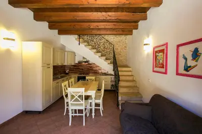 a kitchen and dining room with a table and a staircase at Borgo degli Angeli Wellness & Resort by Le Dhome Sicily in Balestrate