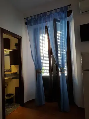 a door with blue curtains next to a window at Casa Vacanze Villa D'Orleans in Palermo