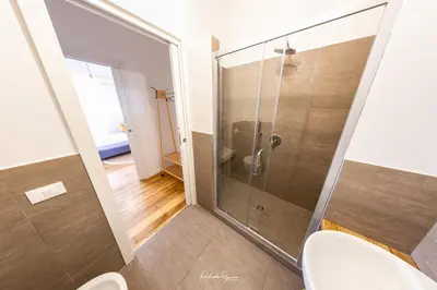a bathroom with a glass shower with a toilet at Sweet Roma 315 in Palermo