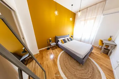 a bedroom with a bed and a yellow wall at Sweet Roma 315 in Palermo