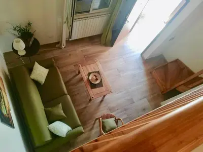 a living room with a green couch and a table at Baglio Reale Apartments in Palermo
