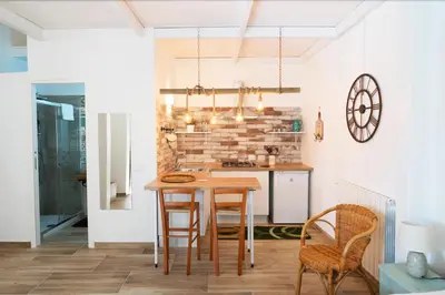 a kitchen with a wooden table and chairs at Baglio Reale Apartments in Palermo