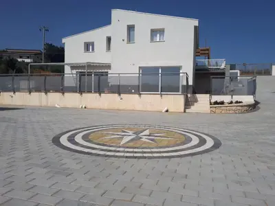 a building with a clock in the middle of a courtyard at Villa Verde in Alcamo
