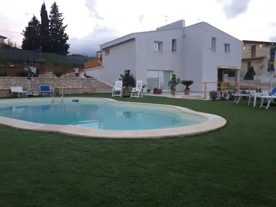 a large swimming pool in the yard of a house at Villa Verde in Alcamo
