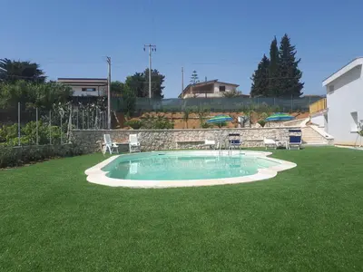 a swimming pool in the middle of a grass yard at Villa Verde in Alcamo