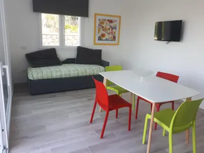 a living room with a table and chairs and a couch at Villa Verde in Alcamo
