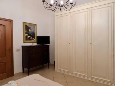 a bedroom with a bed and a dresser and a chandelier at B&B Maria Piddu in Palermo