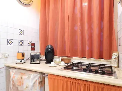 a kitchen counter with a stove top oven next to a window at B&B Maria Piddu in Palermo