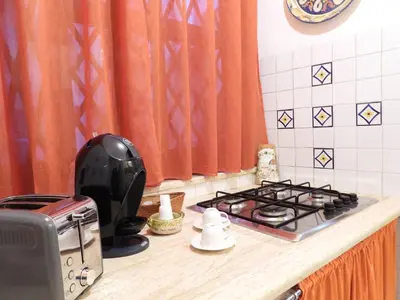 a kitchen counter with a stove and a toaster at B&B Maria Piddu in Palermo