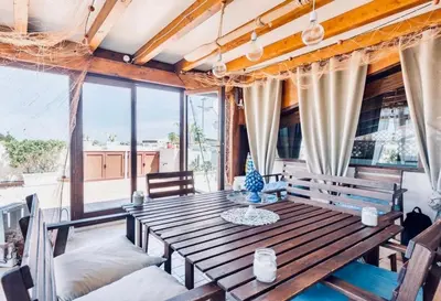 a dining room with a wooden table and chairs at Appartamento BluOltreMare in San Vito lo Capo