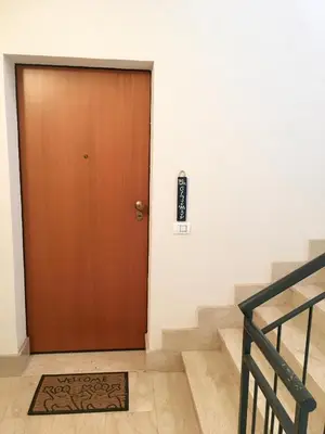 a brown door in a building with stairs at Appartamento BluOltreMare in San Vito lo Capo