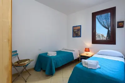 a bedroom with a bed and two night stands and a window at Casa Marisa in San Vito lo Capo