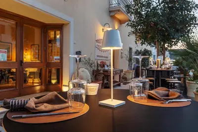 a table with two glasses and a lamp on it at Ghibli Hotel in San Vito lo Capo