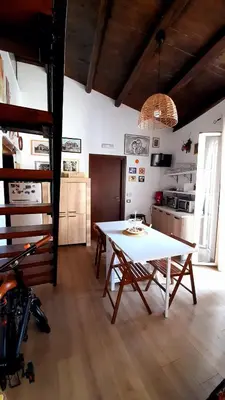 a living room with a table and a kitchen at Guest House Beati Paoli in Palermo