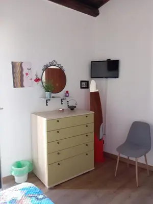 a bedroom with a dresser and a mirror and a chair at Guest House Beati Paoli in Palermo