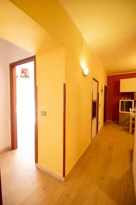 an empty room with yellow walls and wooden floors at Caleidoscopica Bahlara Ballarò in Palermo