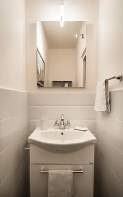 a white bathroom with a sink and a mirror at Casa d'arte Ugdulena con Piscina e Terrazza by Wonderful Italy in Palermo
