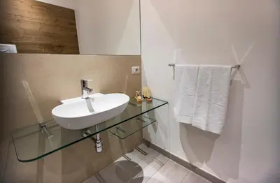 a bathroom with a sink and a glass counter at Suite Quaroni in Palermo