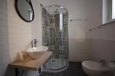 a bathroom with a shower and a sink and a mirror at Il Genoardo Della Zisa in Palermo