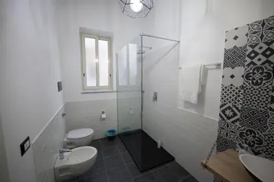 a bathroom with two toilets and a glass shower at Il Genoardo Della Zisa in Palermo