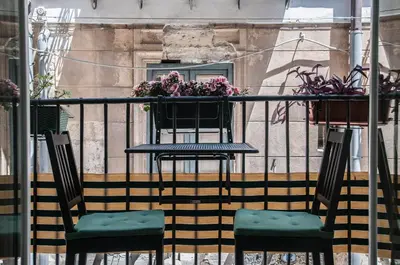 two chairs and a table on a balcony with flowers at Ai Mori in Palermo