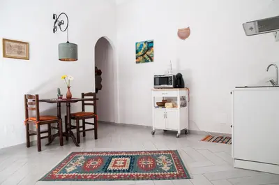 a kitchen with a table and chairs and a refrigerator at Ai Mori in Palermo