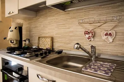 a kitchen with a sink and a stove with hearts on the wall at Casa Assisi in Palermo