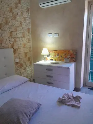 a bedroom with a bed and a desk with a lamp at Casa Assisi in Palermo