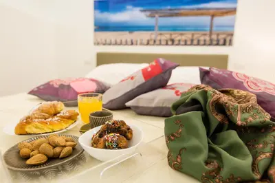 a table topped with plates of pastries and drinks at Palermo In Suite Aparthotel in Palermo