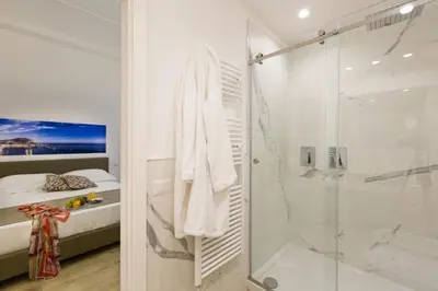a white bathroom with a shower and a bed at Palermo In Suite Aparthotel in Palermo