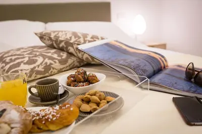 a table with a tray of food on a bed at Palermo In Suite Aparthotel in Palermo