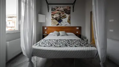 a bedroom with a bed with a poster on the wall at Suite del Ponte Normanno in Palermo