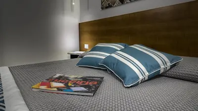 a book on a bed with pillows and a magazine at Suite del Ponte Normanno in Palermo