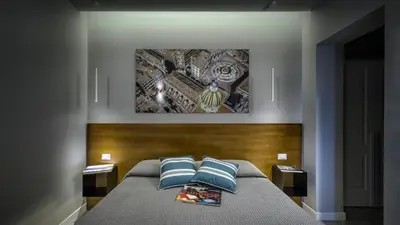 a bedroom with a bed with two blue pillows at Suite del Ponte Normanno in Palermo