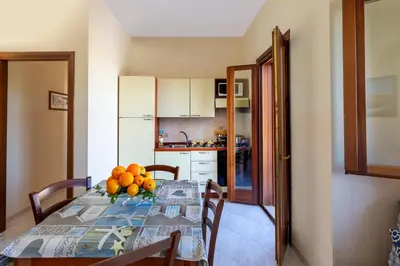 a kitchen with a table with a bowl of fruit on it at Residence Smeraldo in San Vito lo Capo