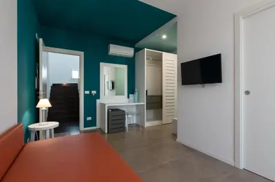 a room with a couch and a desk and a tv at Affittacamere Sirius in San Vito lo Capo