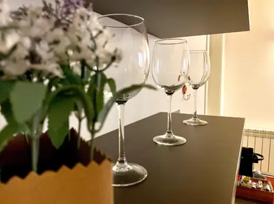 three wine glasses sitting on a table with flowers at WelcHomeLoft in Palermo