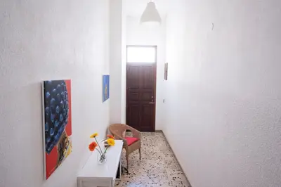 a hallway with a table and a chair and a door at Casa Lisa a due passi dal mare con ampio giardino in San Vito lo Capo