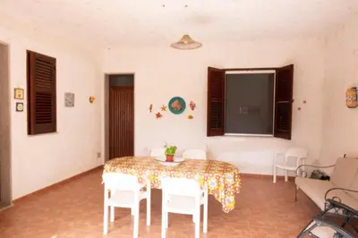 a living room with a table and chairs and a tv at Casa Lisa a due passi dal mare con ampio giardino in San Vito lo Capo