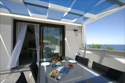 a table on a balcony with a view of the ocean at Villa Antonia - Vasca Idromassaggio Terrazza Vista Mare in San Vito lo Capo