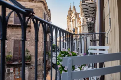 a balcony with a white bench and a building at Casa Salinas Centro Storico in Palermo