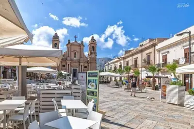 a town square with tables and chairs and buildings at GíeffeHOUSE in Terrasini