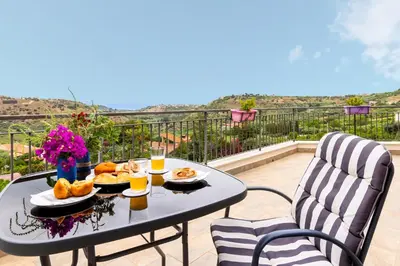 a table with food and drinks on a balcony at Granatelli Holiday Home in Altavilla Milicia